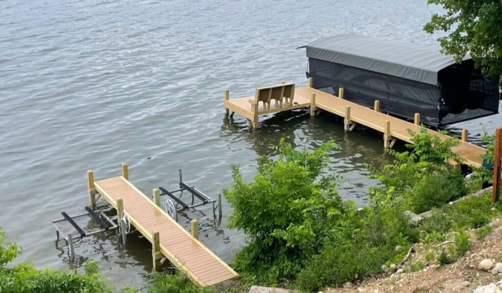 Two custom composite docks on Okauchee Lake. One L-shaped dock with a wood bench and another dock for jet skis, built by Rock Docks Wisconsin.