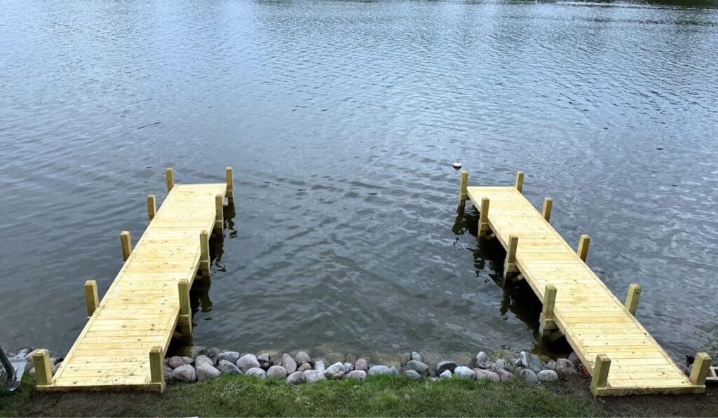 Two straight custom wood docks side by side in an Okauchee Lake channel, built by Rock Docks Wisconsin.